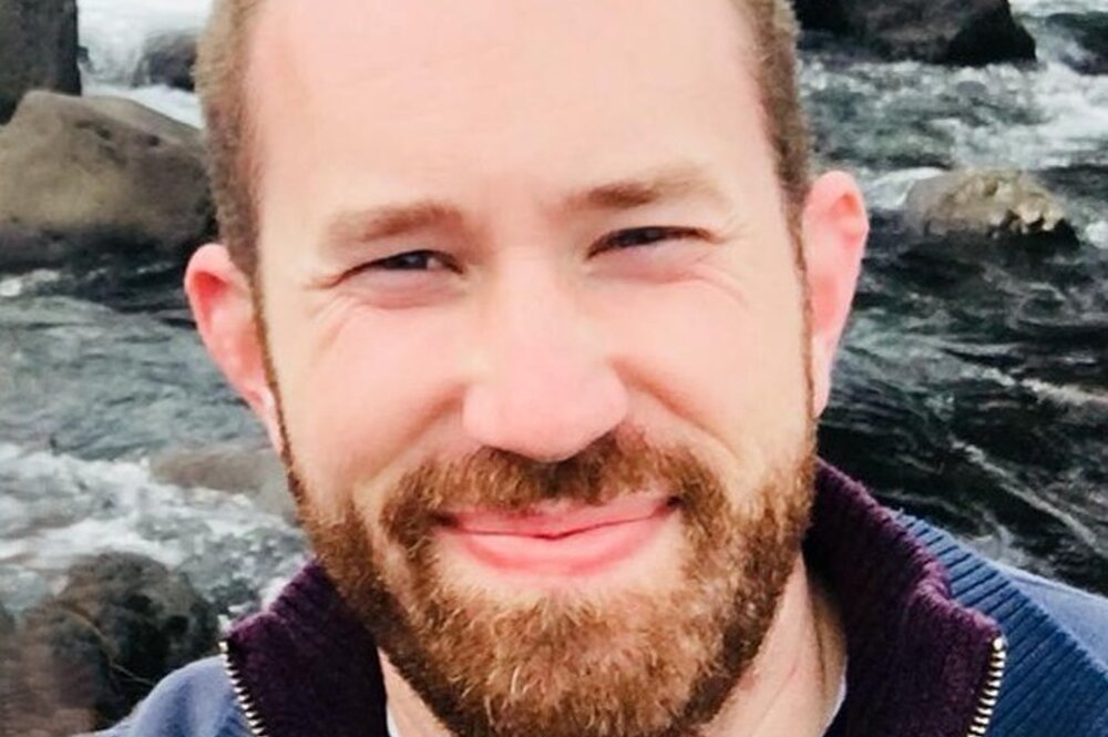 Jordan McAlister in front of a waterfall.